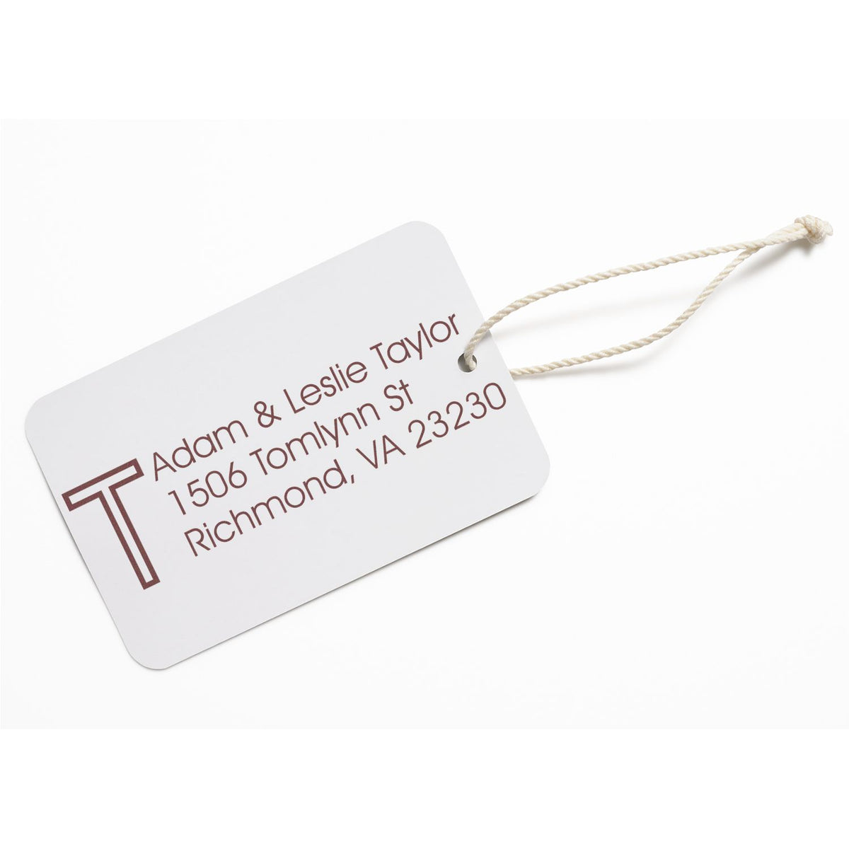 Custom return address rubber stamp design on a personalized luggage tag with name and Richmond, VA address.