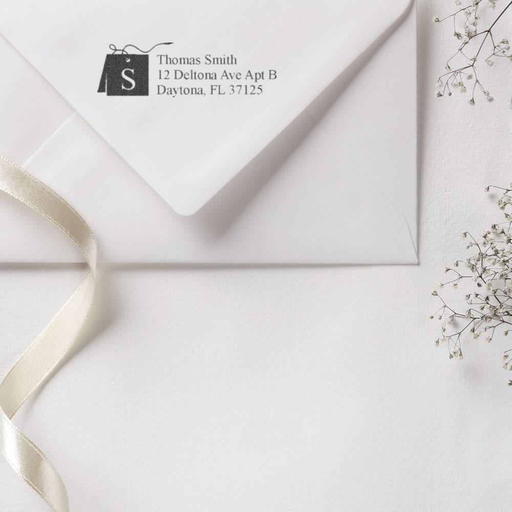 Custom return address rubber stamp with monogram on elegant wedding envelope and stationery.