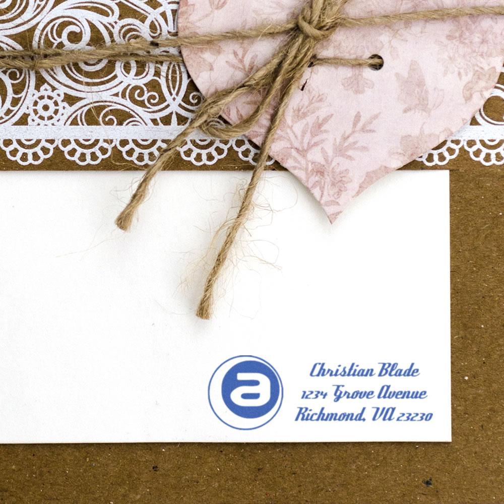 Custom return address rubber stamp on white envelope with monogram logo, perfect for personalized wedding or business stationery.