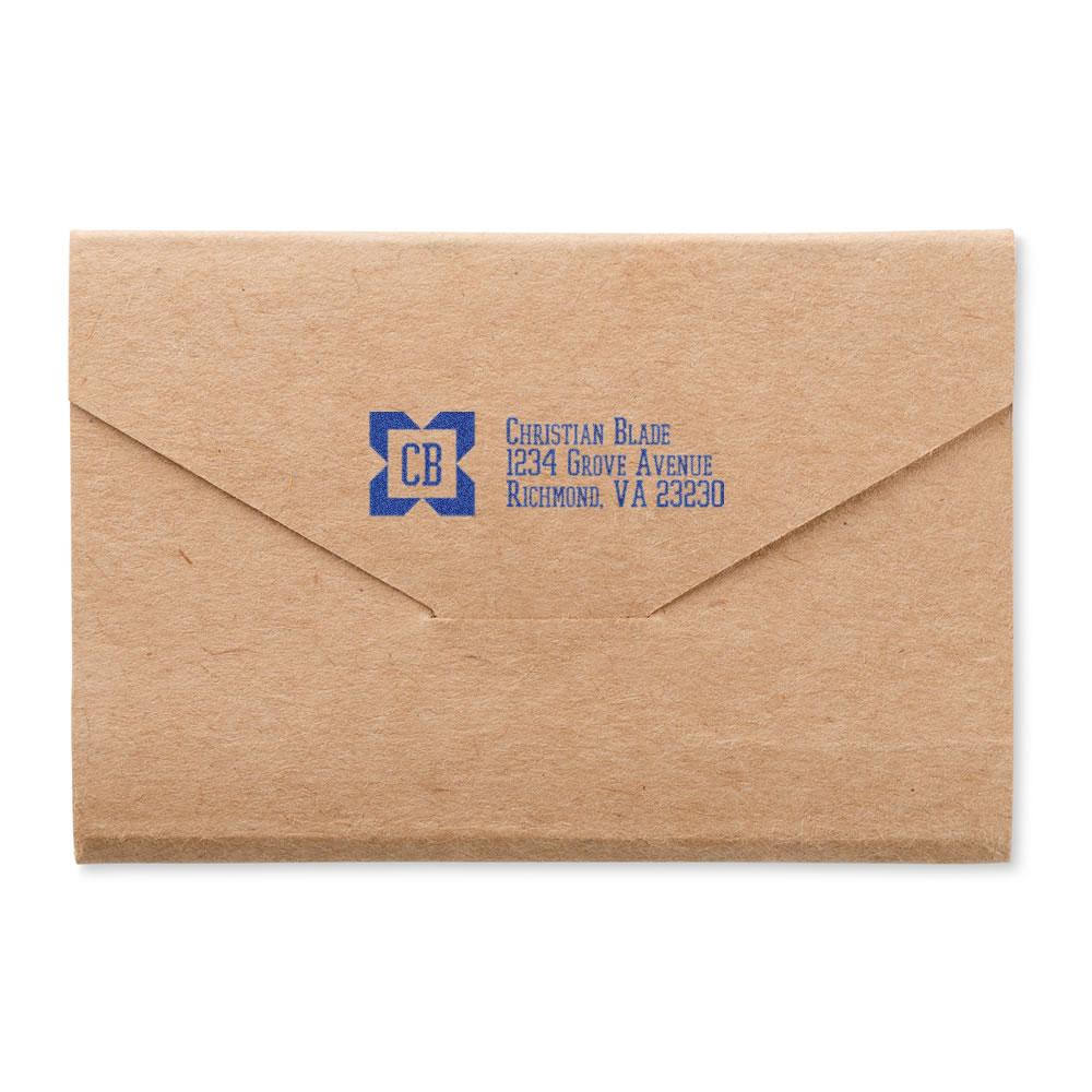 Custom return address rubber stamp on kraft envelope with blue logo and business mailing details.