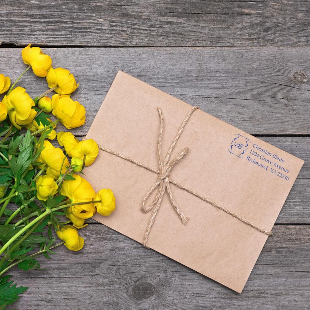 Custom return address rubber stamp on kraft envelope tied with twine, ideal for branded mailing, gifts, or stationery.