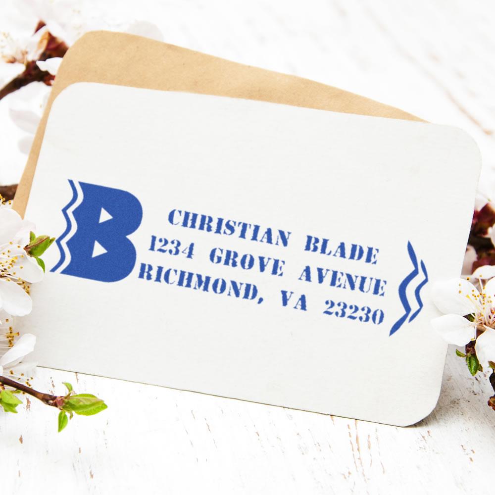 Custom return address rubber stamp on envelope with blue imprint for Christian Blade, 1234 Grove Avenue, Richmond, VA 23230.