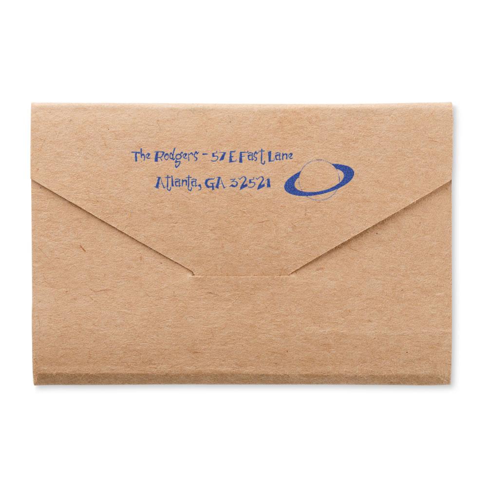 Custom return address rubber stamp on kraft envelope with blue ink imprint, featuring name, Atlanta address, and logo.