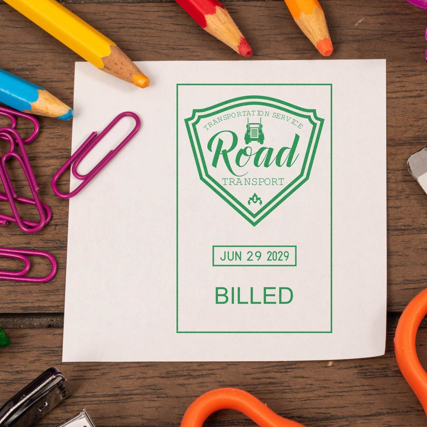 Road transport billing document on a wooden desk with colorful pencils and paper clips.