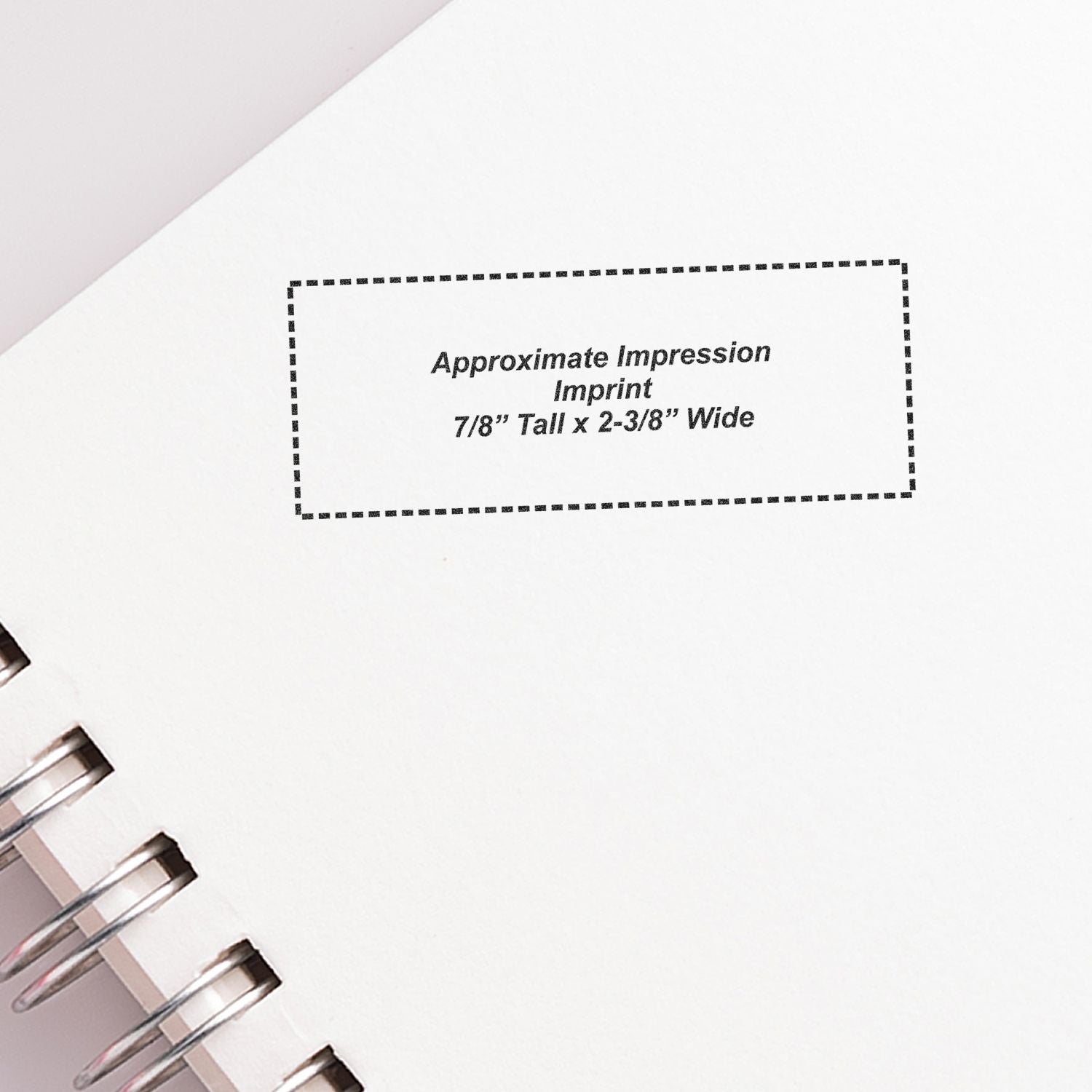 Blank spiral notebook page with dotted custom imprint area labeled Approximate Impression, 7/8 tall by 2-3/8 wide.