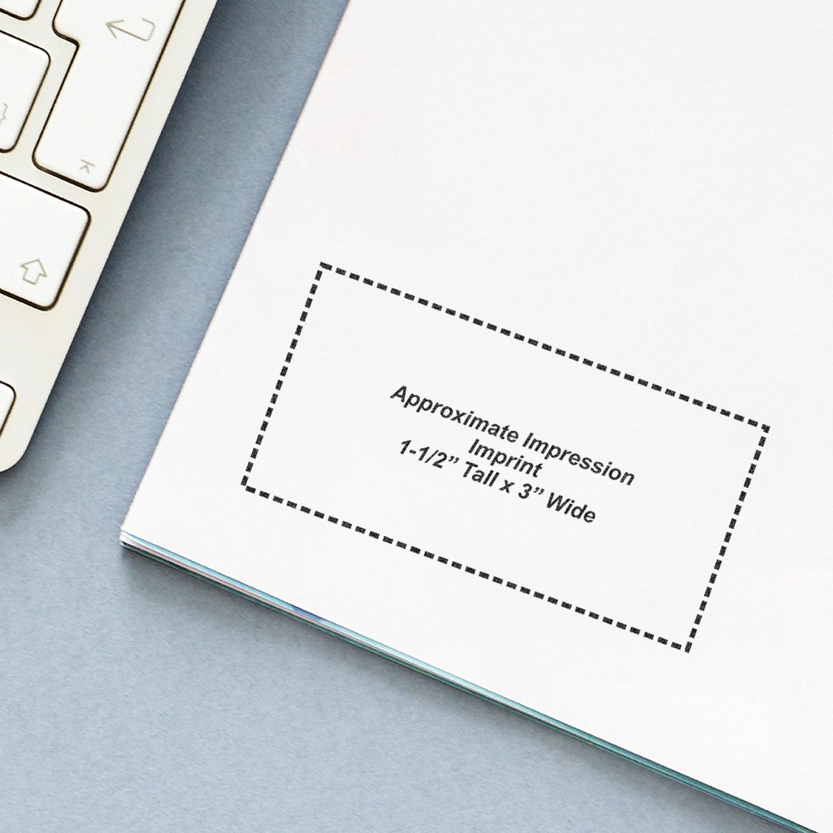Close-up of a printable brochure template showing an approximate impression imprint size of 1-1/2 inches tall by 3 inches wide beside a laptop keyboard.