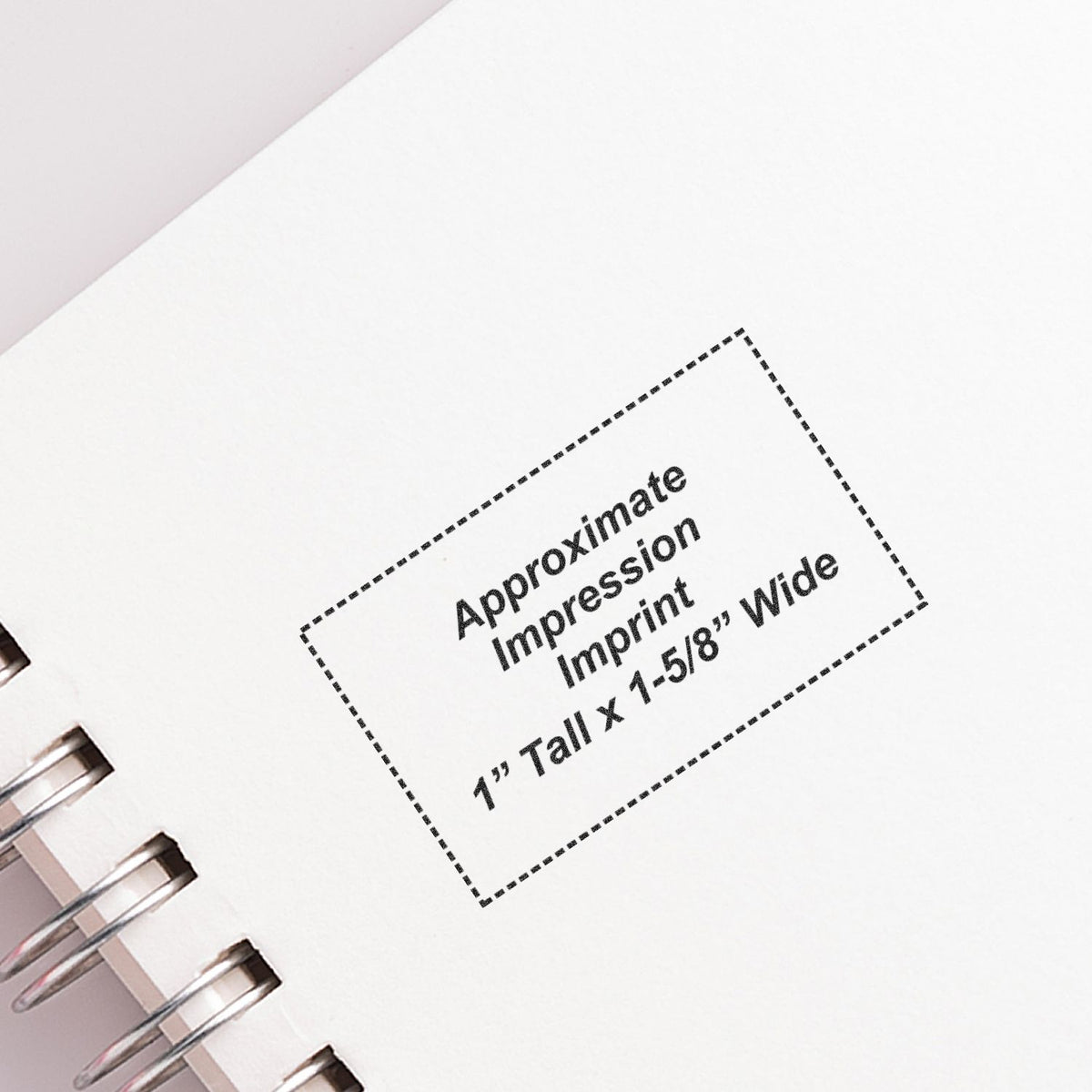 Close-up of a spiral notebook page showing an approximate custom imprint area, 1" tall by 1-5/8" wide.