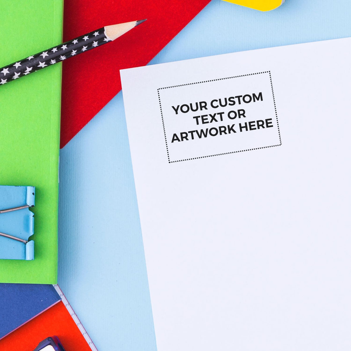 Colorful stationery flat lay with blank white paper, pencil, and binder clips for custom text or artwork design mockup