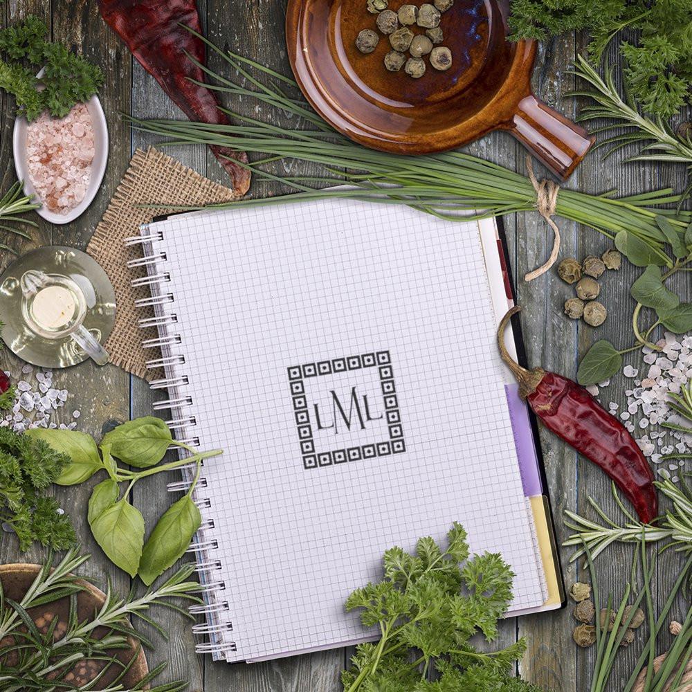 Custom monogram rubber stamp design on notebook paper, styled with herbs and spices for branding and packaging.