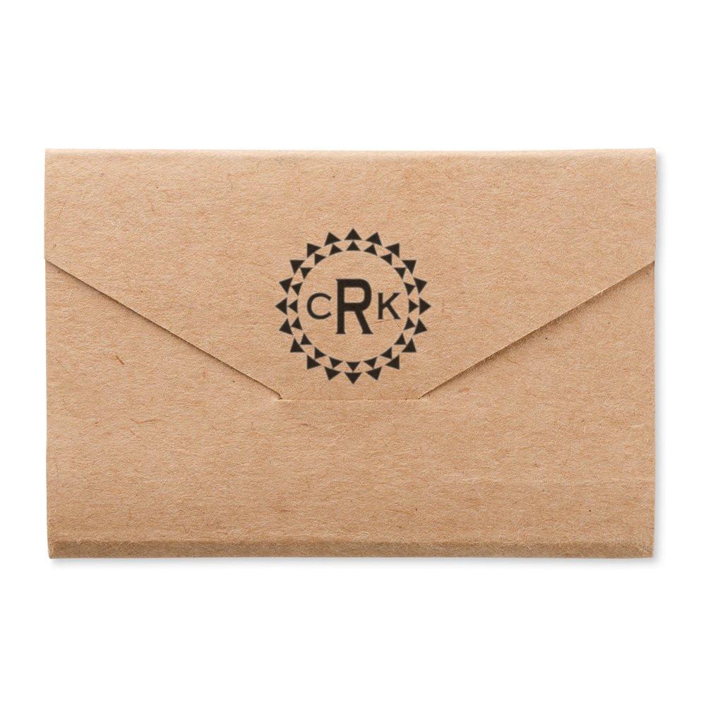 Custom monogram rubber stamp on kraft envelope for wedding invitations, business branding, or packaging.