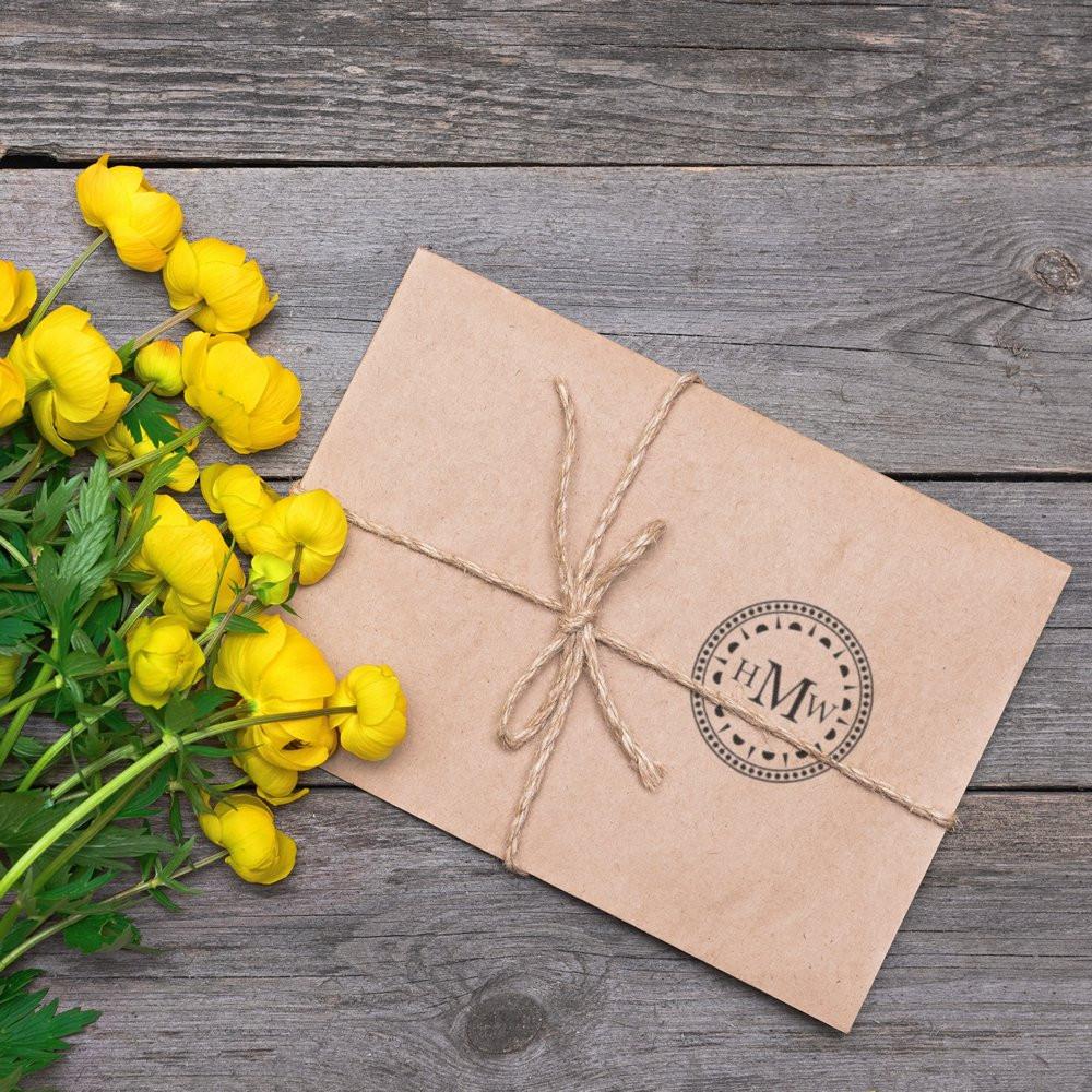 Custom monogram rubber stamp on kraft envelope tied with twine, perfect for personalized packaging and handmade branding.