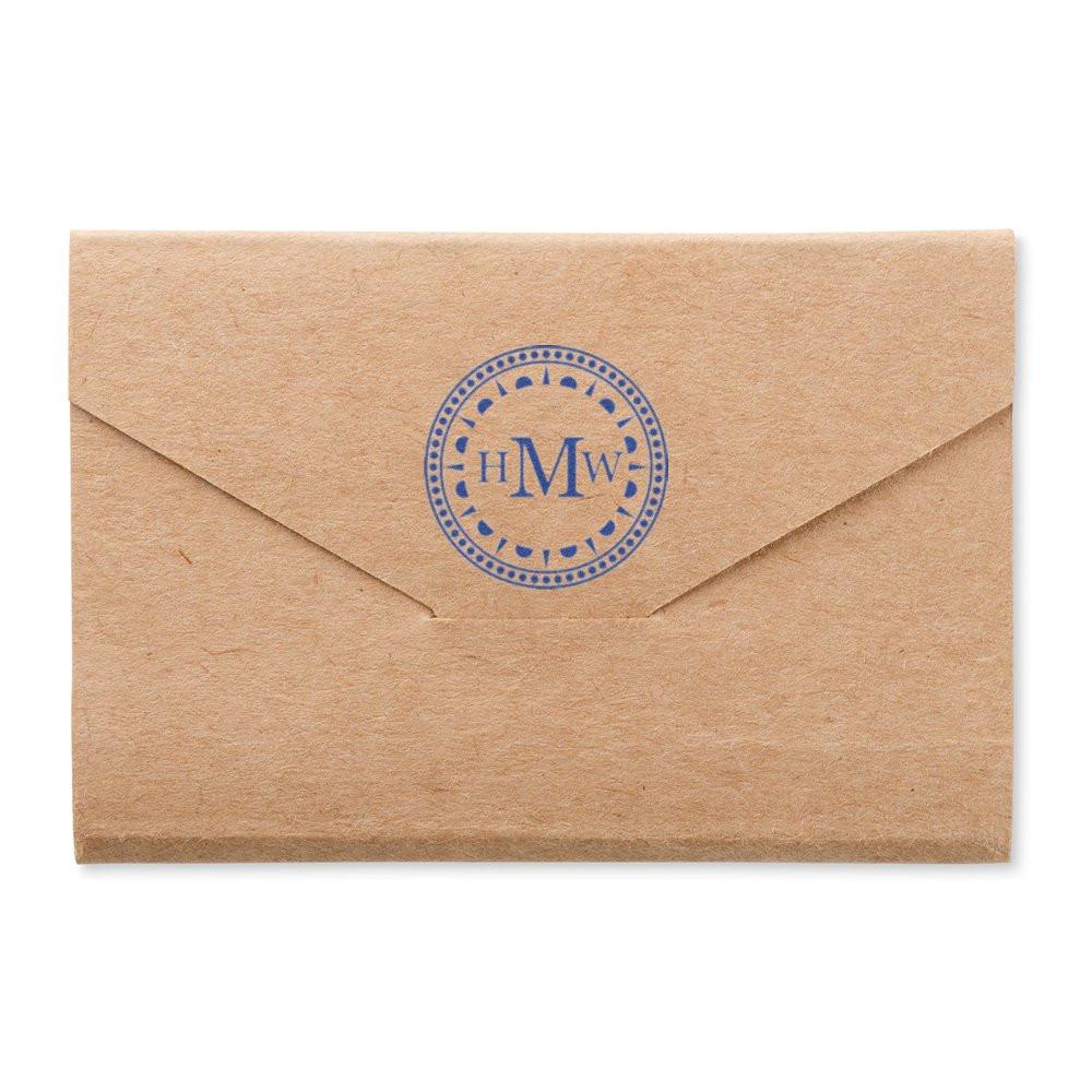 Custom rubber stamp monogram on kraft envelope for personalized stationery, wedding invitations, and branded mailings.