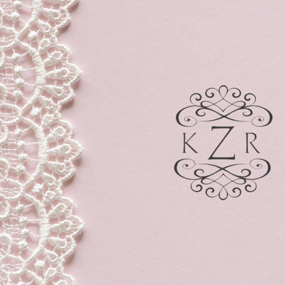 Elegant pink lace background featuring ornate monogram ZKR, decorative flourishes for wedding or vintage invitation design.
