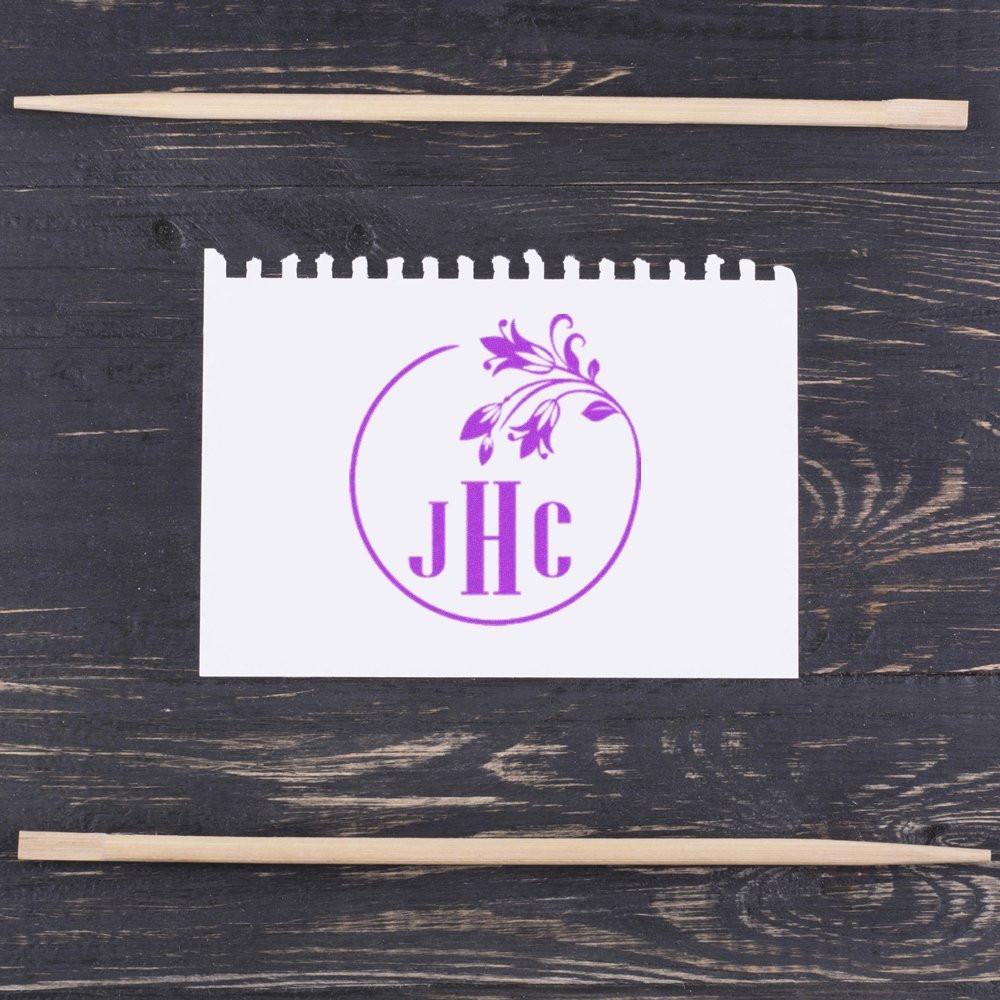 Custom monogram rubber stamp with floral wreath and JHC initials for personalized stationery and branding.