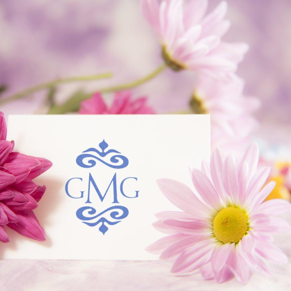Custom GMG monogram rubber stamp design on white card with pastel flowers, perfect for elegant wedding stationery and branding.