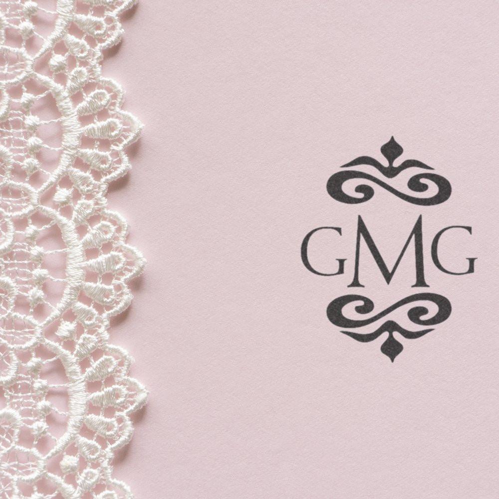 Custom GMG monogram rubber stamp design for wedding invitations and stationery on soft pink paper with lace trim.