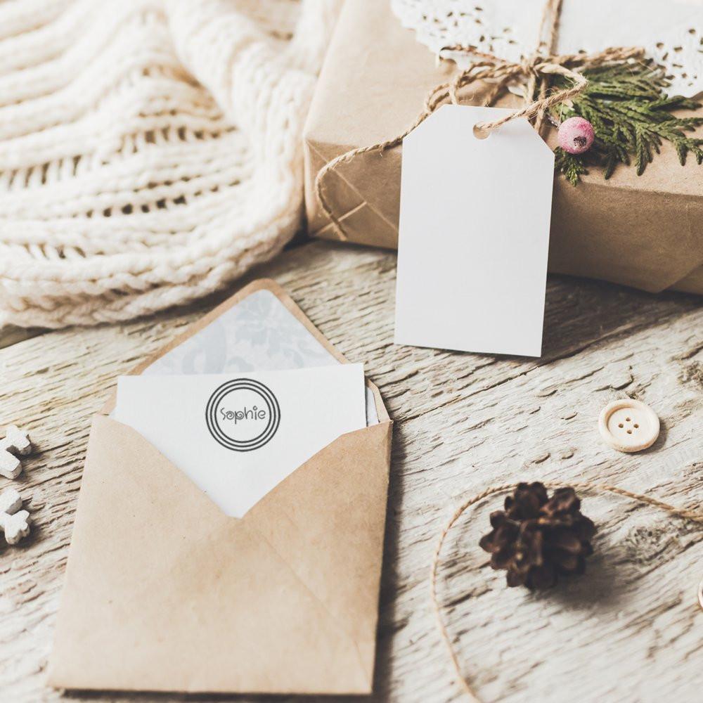 Custom rubber stamp on kraft envelope with blank gift tag, perfect for personalized wedding stationery and packaging.