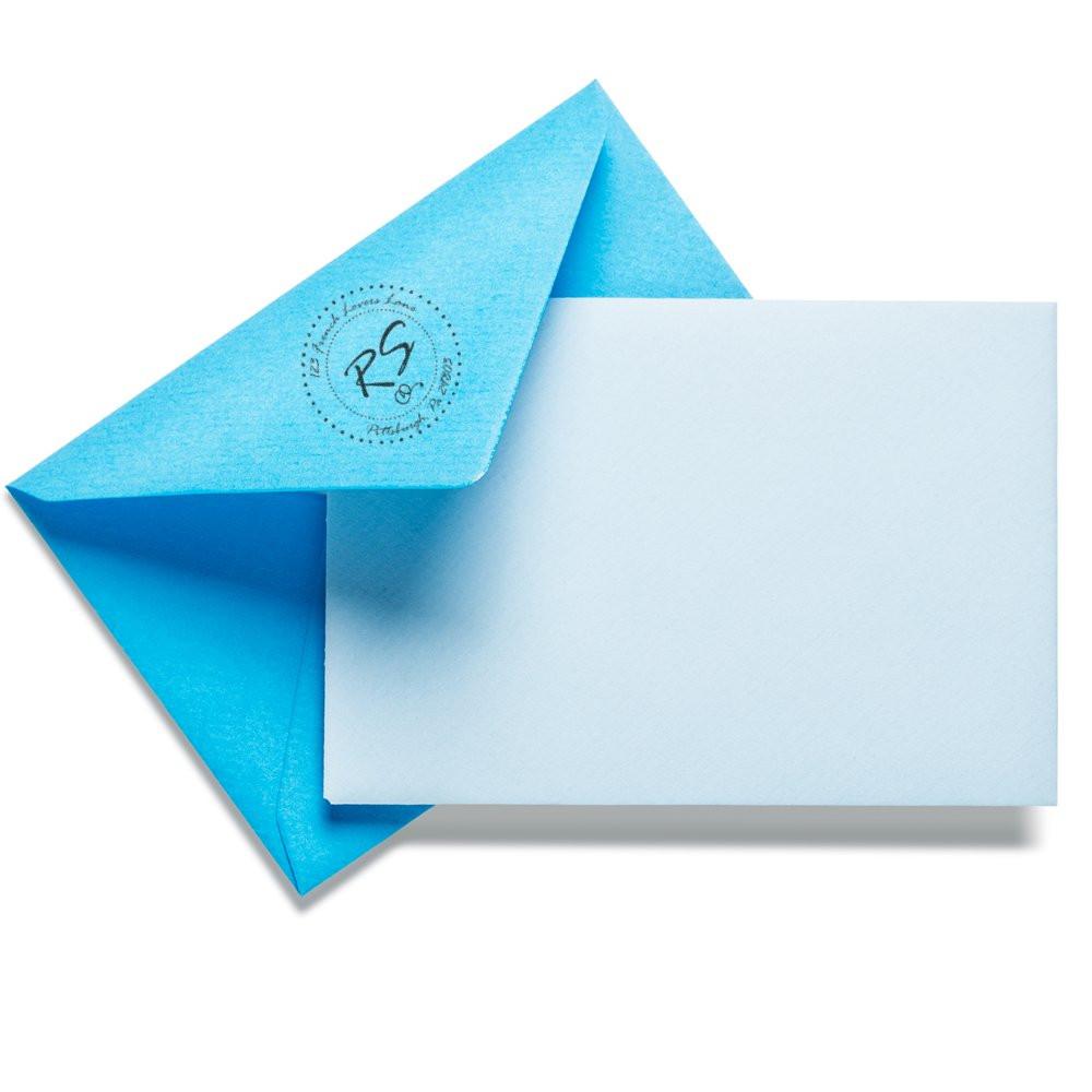 Custom rubber stamp seal on blue envelope with blank card for wedding invitations.