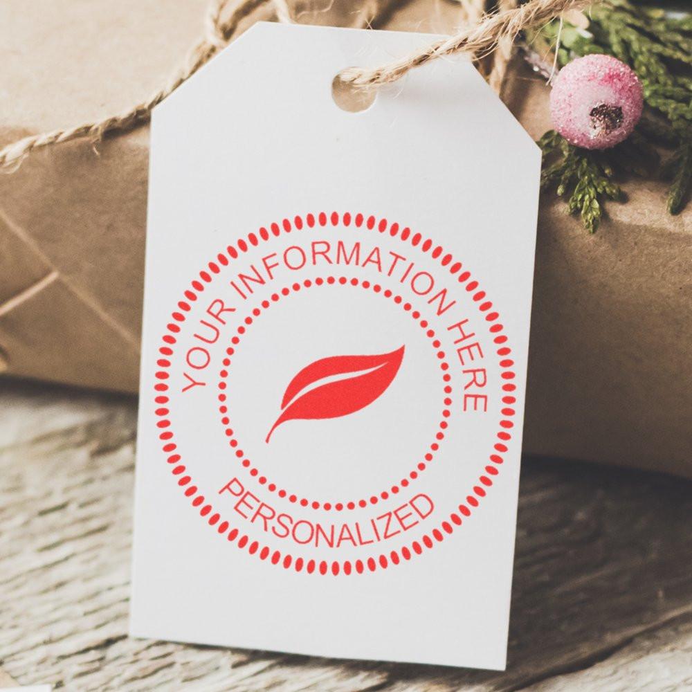 Custom rubber stamp imprint on gift tag with personalized logo and leaf design for branding and packaging