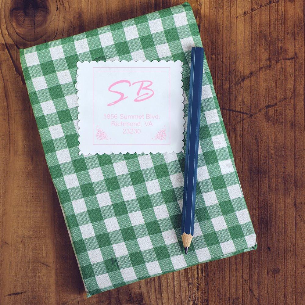 Custom return address rubber stamp on stationery, featuring initials and address for personalized envelopes.