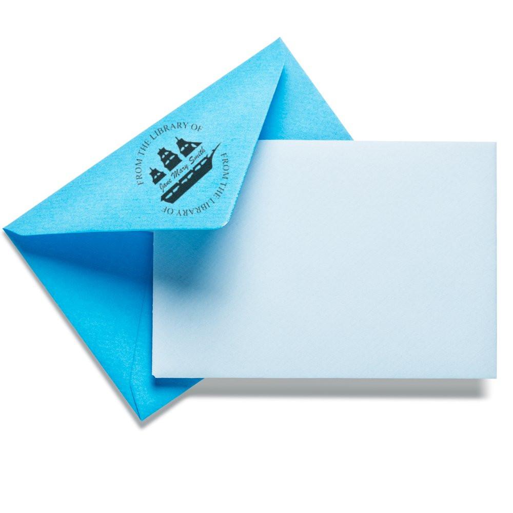Custom rubber stamp on blue envelope reading From the Library Of for personalized stationery and bookplate use
