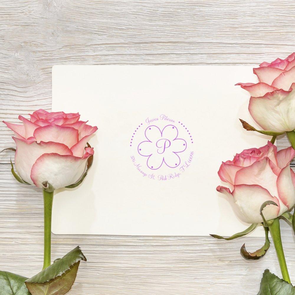 Personalized floral monogram rubber stamp on stationery, perfect for custom wedding invitations, envelopes, and return addresses.