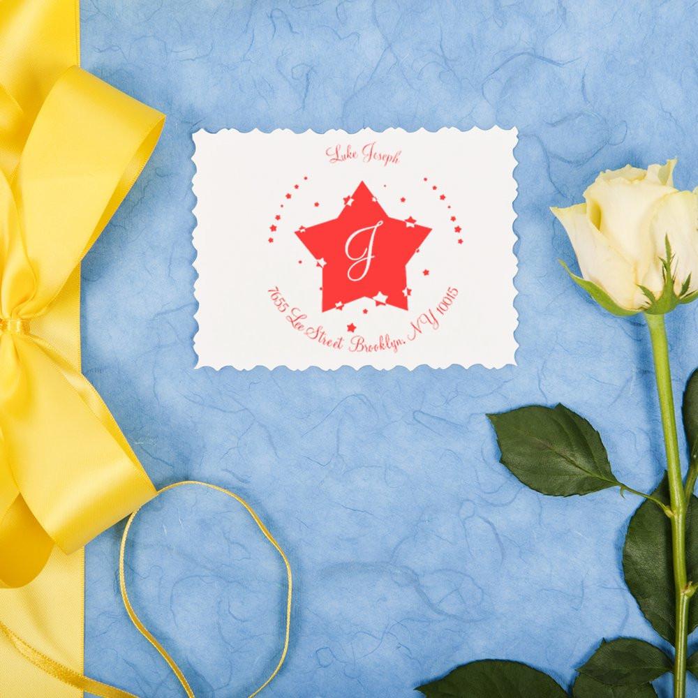 Vintage greeting card featuring a red star monogram, yellow ribbon and white rose on a blue background, celebratory design