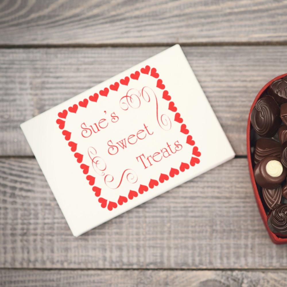 Custom rubber stamp branding on a chocolate gift box reading Sues Sweet Treats with a heart border.