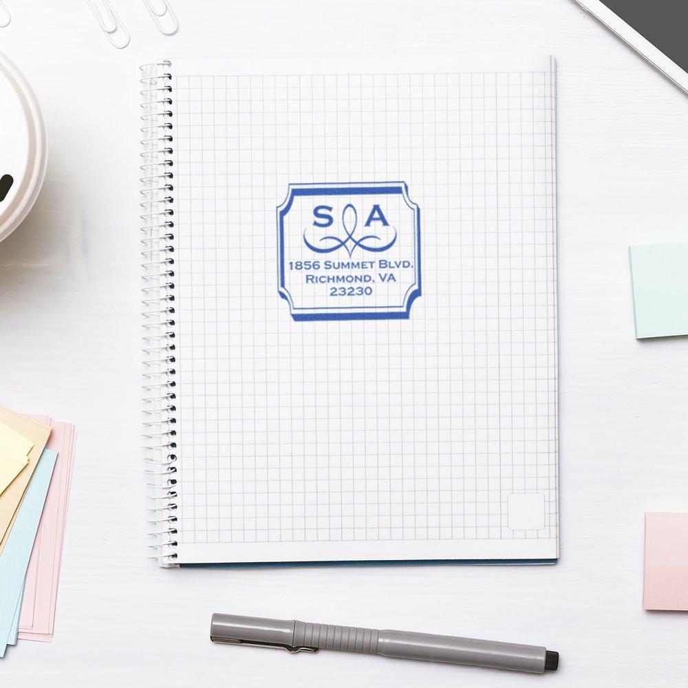 Custom rubber address stamp impression on notebook with blue monogram and Richmond, VA return address.