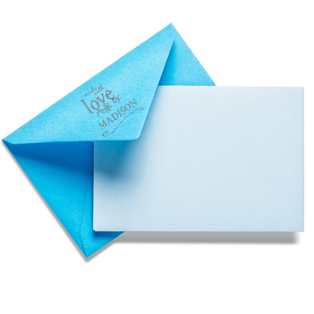 Custom rubber stamp on blue envelope with personalized Made with Love by Madison design for wedding invitations and stationery.