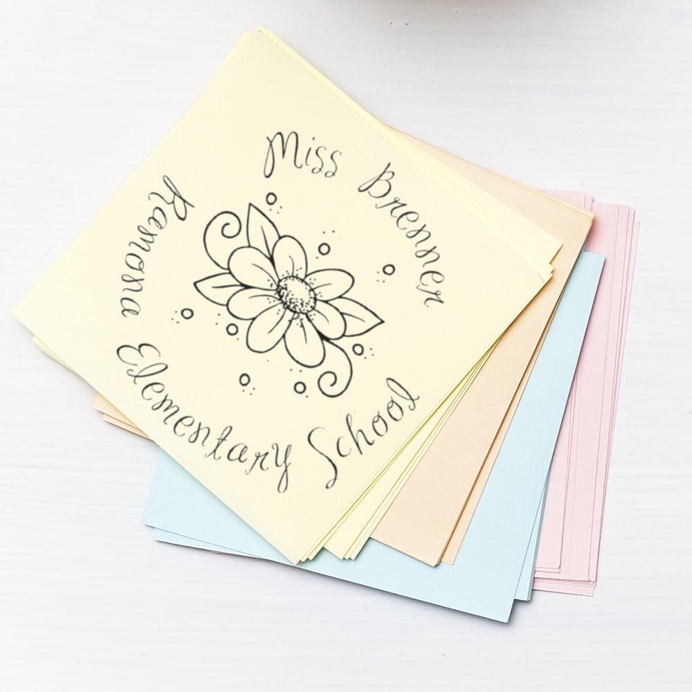 Custom floral rubber stamp for an elementary school, displayed on pastel cardstock samples.