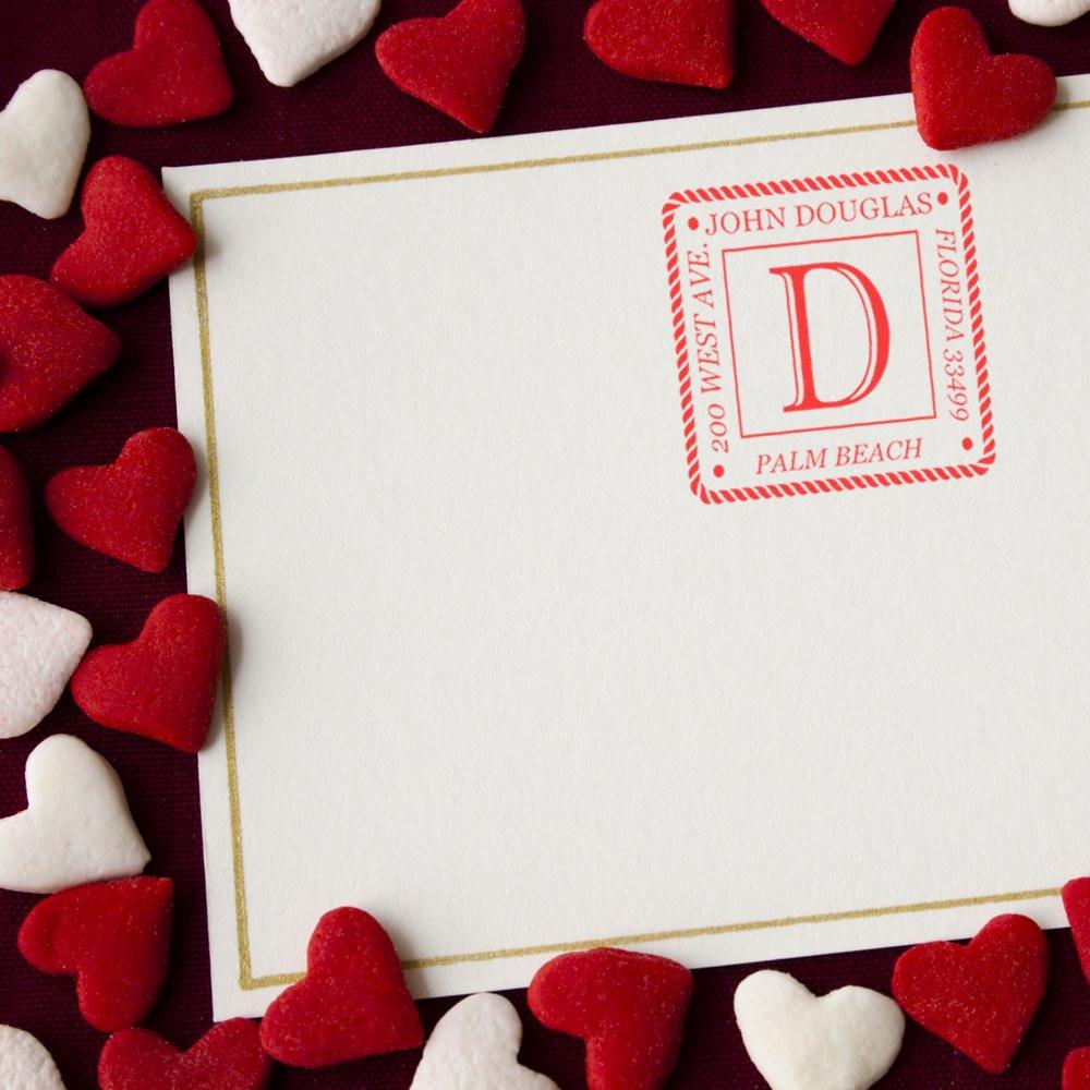 Personalized return address rubber stamp on a white envelope, surrounded by red and white hearts for Valentines mail.