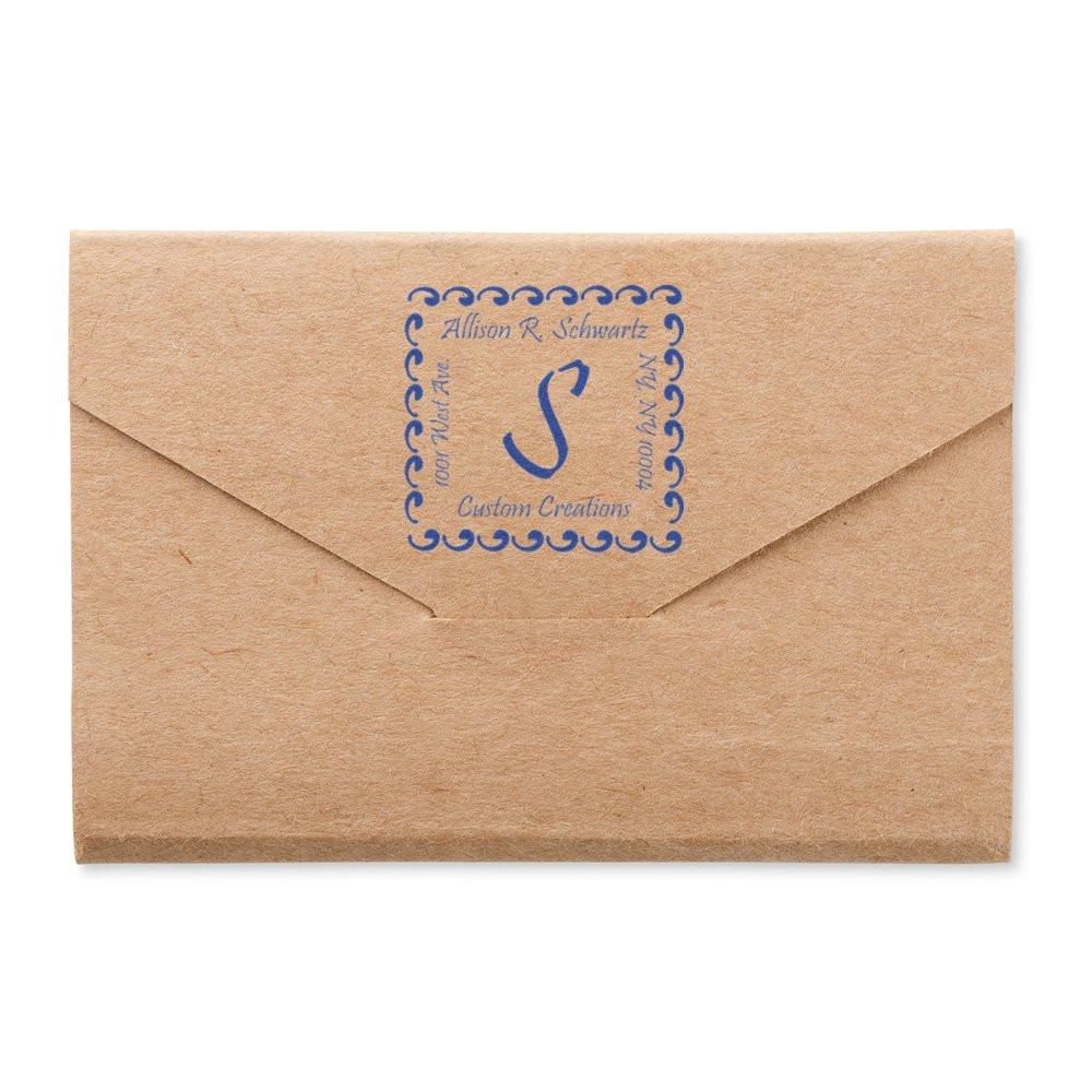 Custom return address rubber stamp on a kraft envelope with monogram and name in blue ink for personalized mailing.