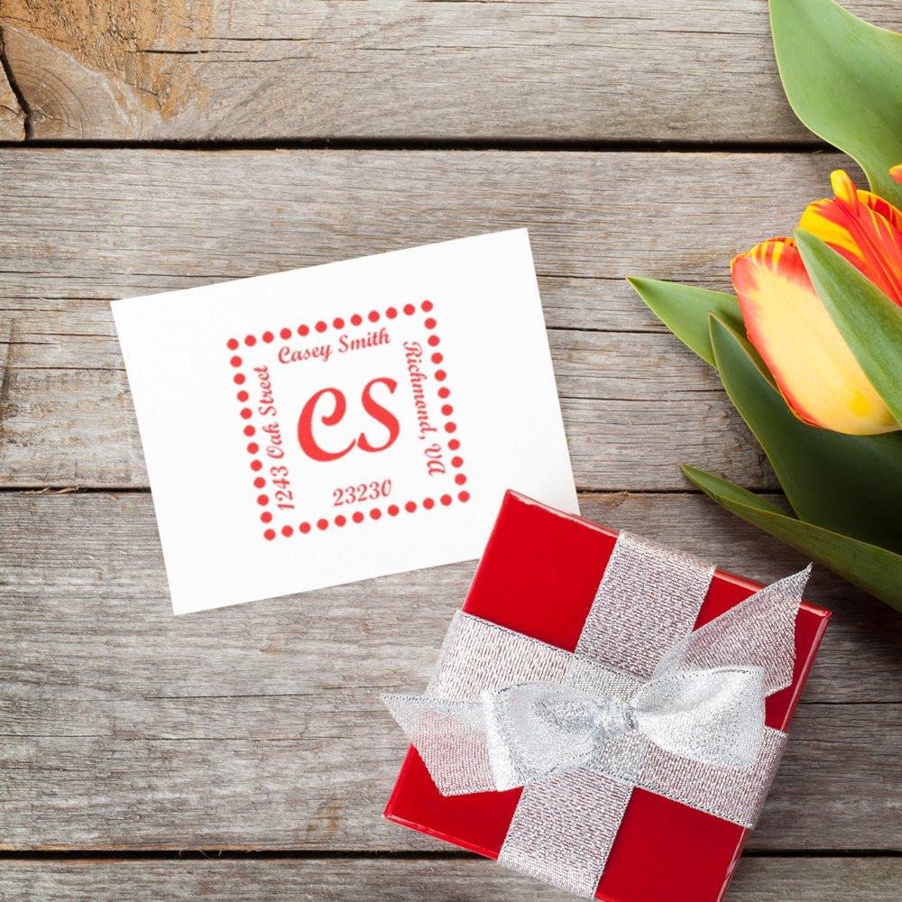 Custom rubber stamp return address with monogram CS on note card, beside a gift box and flowers, ideal for weddings and mailings.