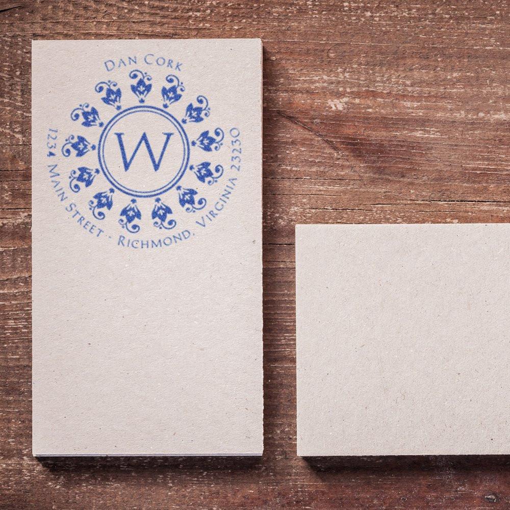 Custom return address rubber stamp with floral W monogram and business address on stationery cards.