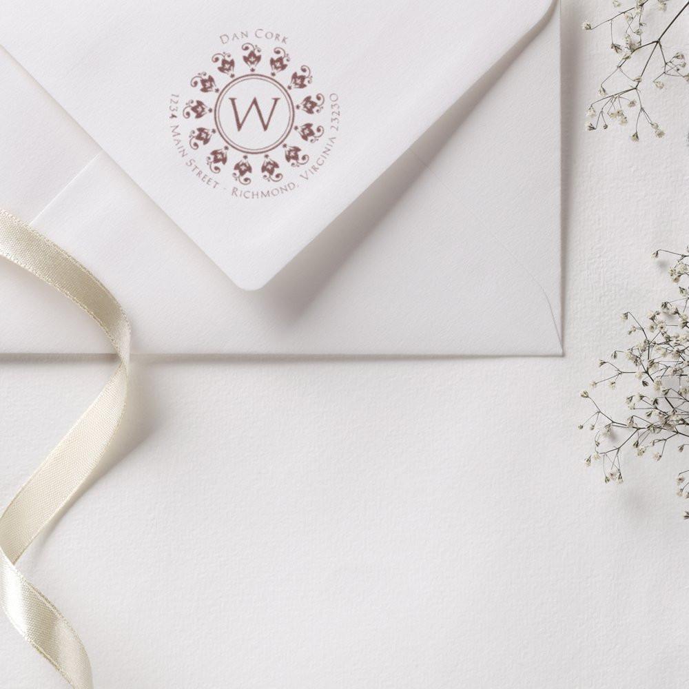 Custom monogram rubber stamp on wedding envelope with floral crest return address design