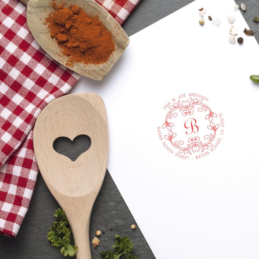 Custom monogram address rubber stamp imprint on white stationery for personalized wedding invitations.