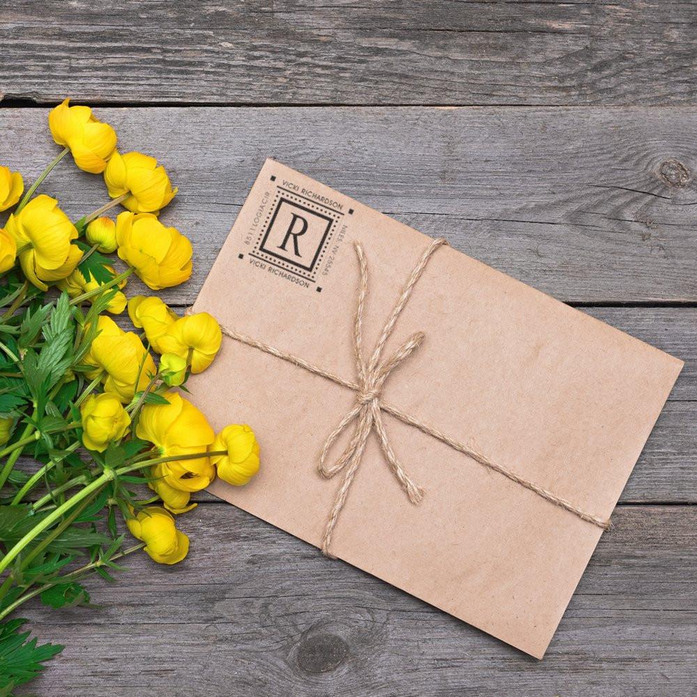 Personalized monogram rubber stamp on kraft envelope tied with twine, ideal for custom stationery and gift packaging.