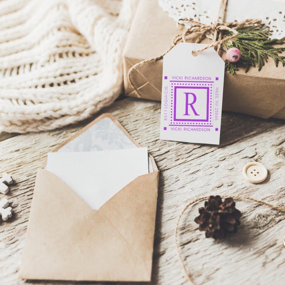 Personalized rubber stamp monogram on a gift tag with rustic envelope, ideal for custom stationery, wedding favors, and branding.
