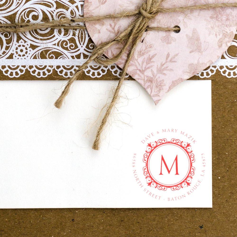 Custom return address rubber stamp with monogram on a wedding envelope, featuring an ornate circular design for personalized stationery.