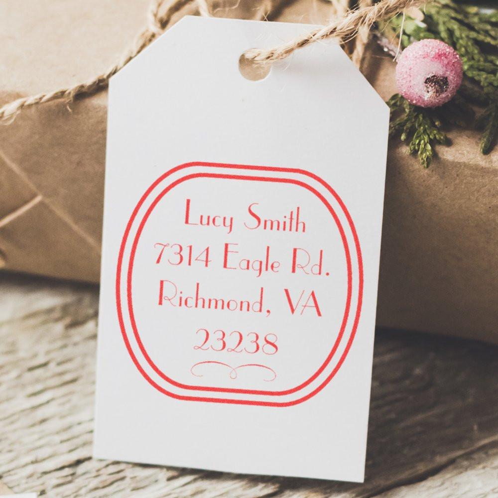 Personalized return address rubber stamp on a white gift tag with red imprint, ideal for wedding favors and packaging.