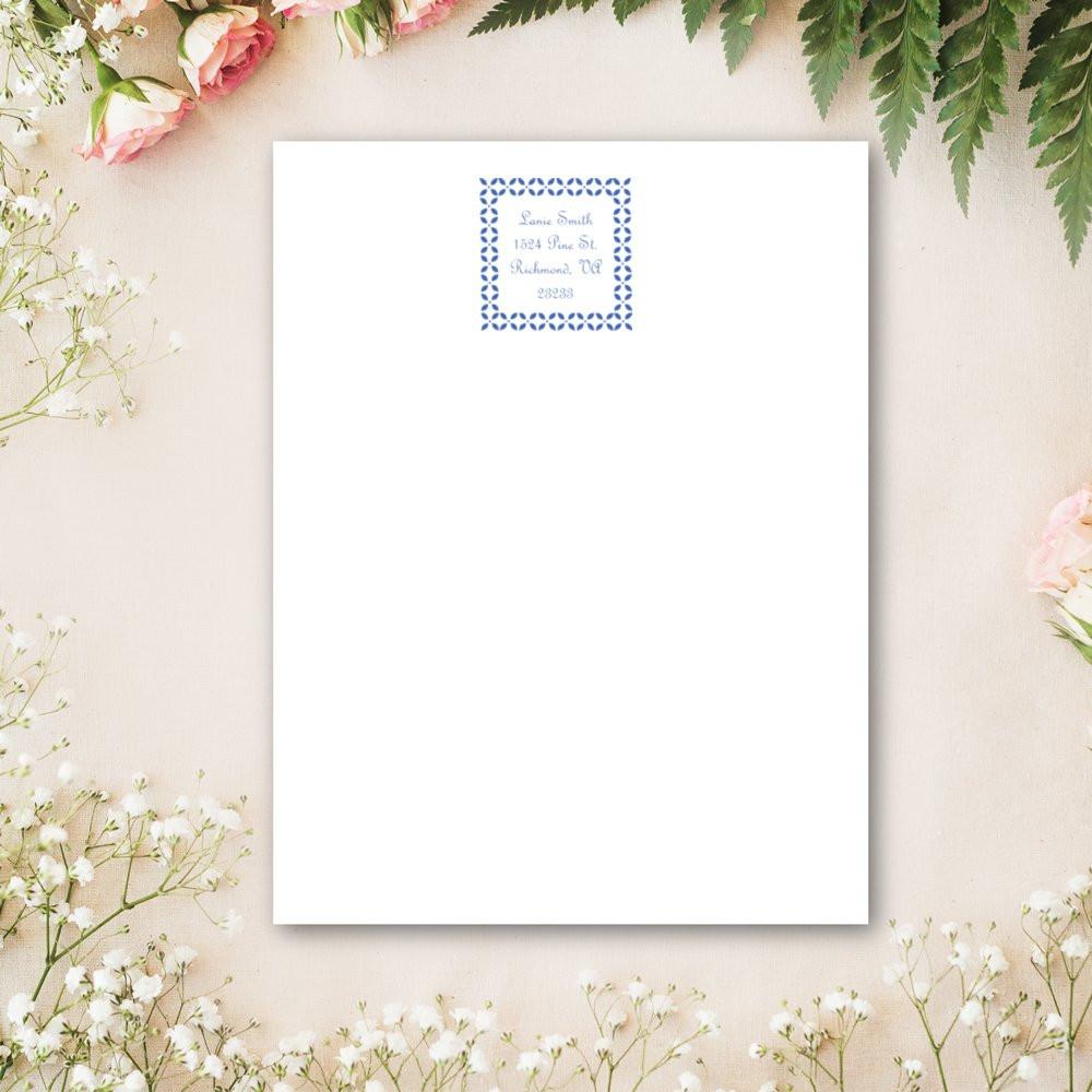 Custom return address rubber stamp on white stationery with blue floral border and personalized name and address.