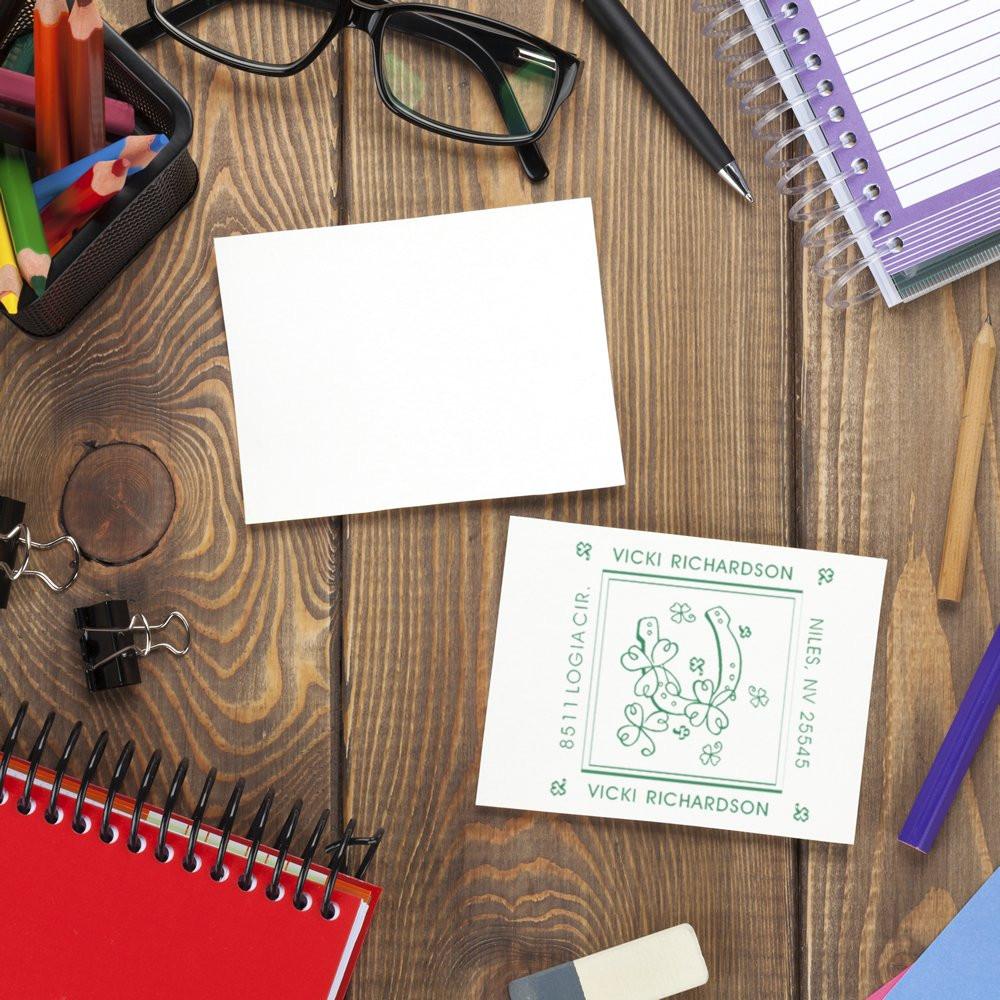 Personalized rubber stamp return address sample beside a blank card on a desk, ideal for stationery branding.