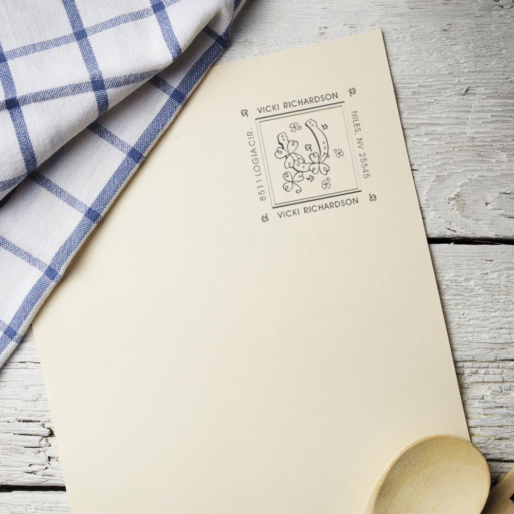 Personalized return address rubber stamp with floral monogram on cream stationery, ideal for custom envelope marking.