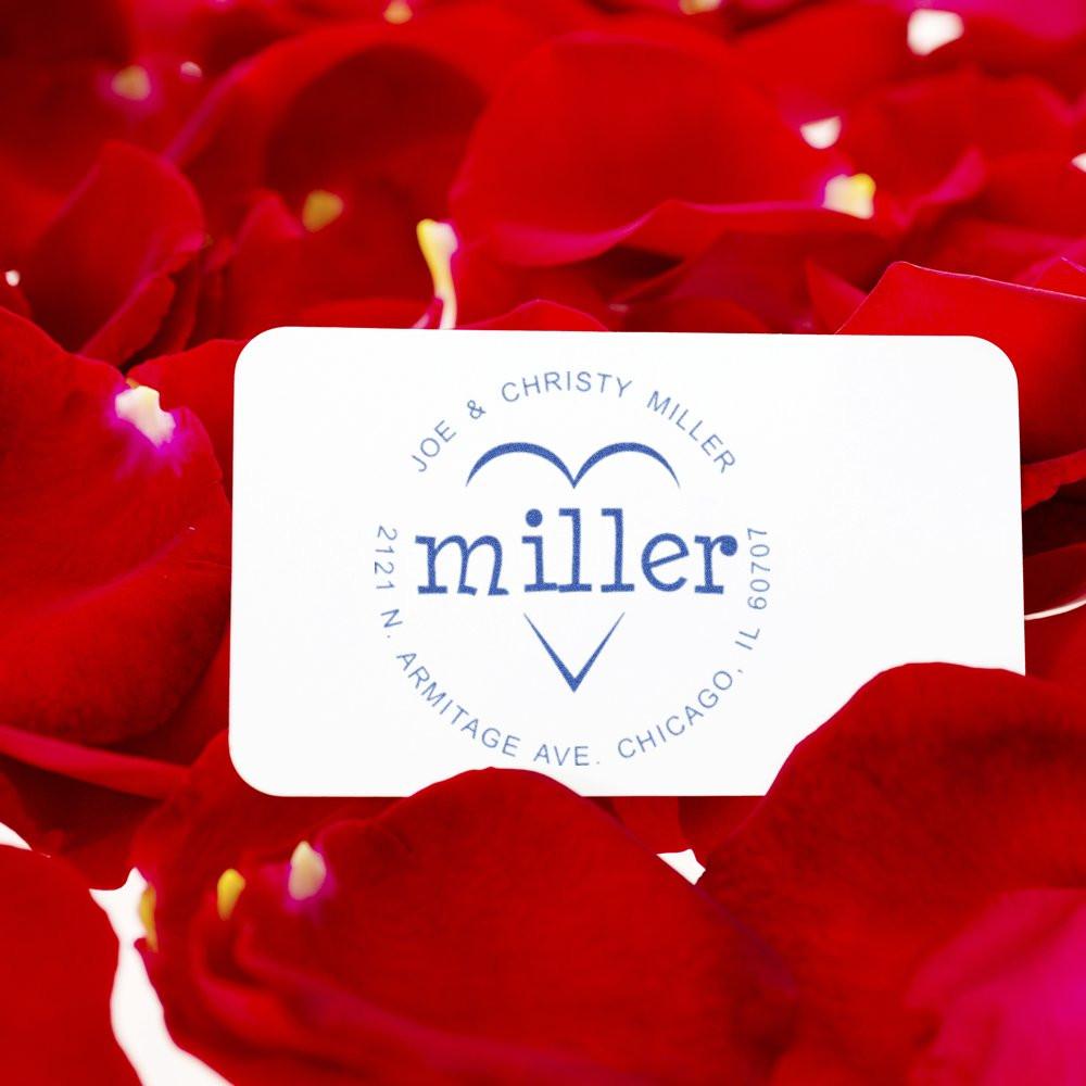 Custom return address rubber stamp with Miller monogram, styled on red rose petals for wedding invitations and stationery.