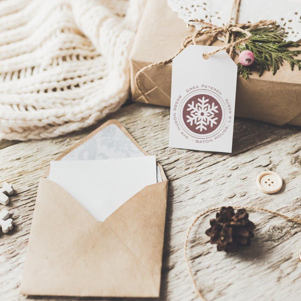 Festive Christmas gift tags and greeting envelope on rustic wood, winter snowflake design for seasonal message packaging