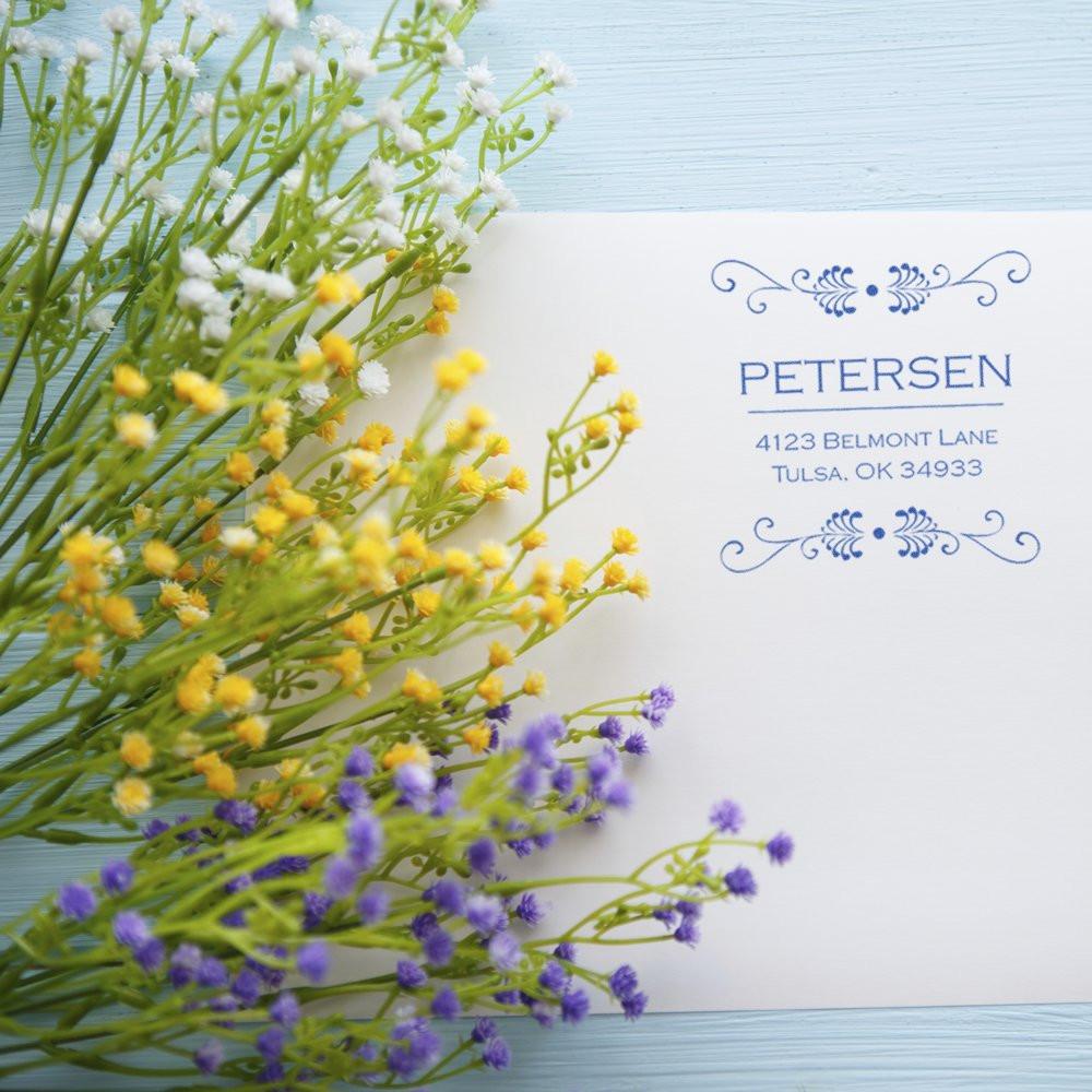 Custom rubber address stamp sample with floral accents, featuring the Petersen name and Tulsa return address.