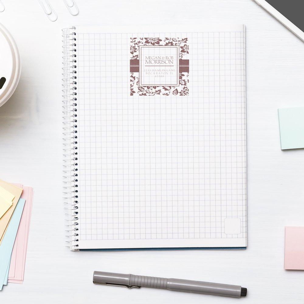 Custom address rubber stamp impression on a grid notebook, ideal for personalized stationery and business branding.