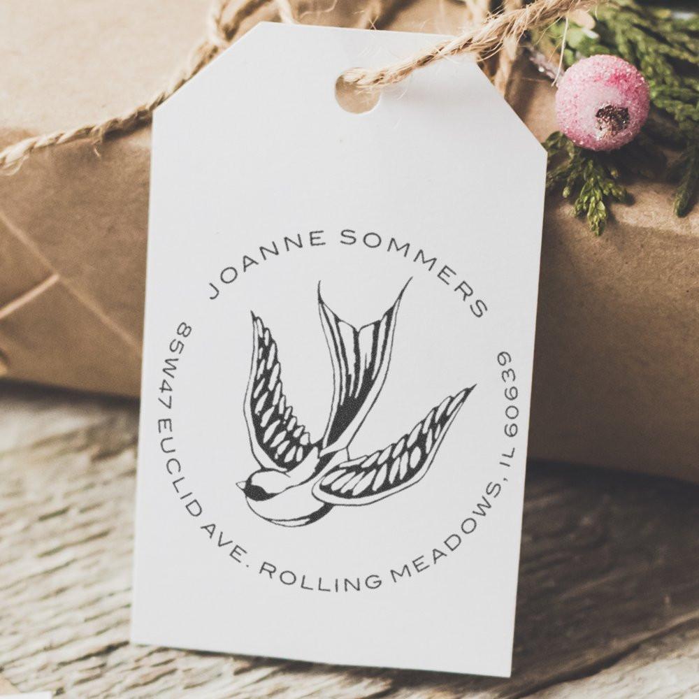 Custom return address rubber stamp with bird design on a kraft gift tag for branded packaging.