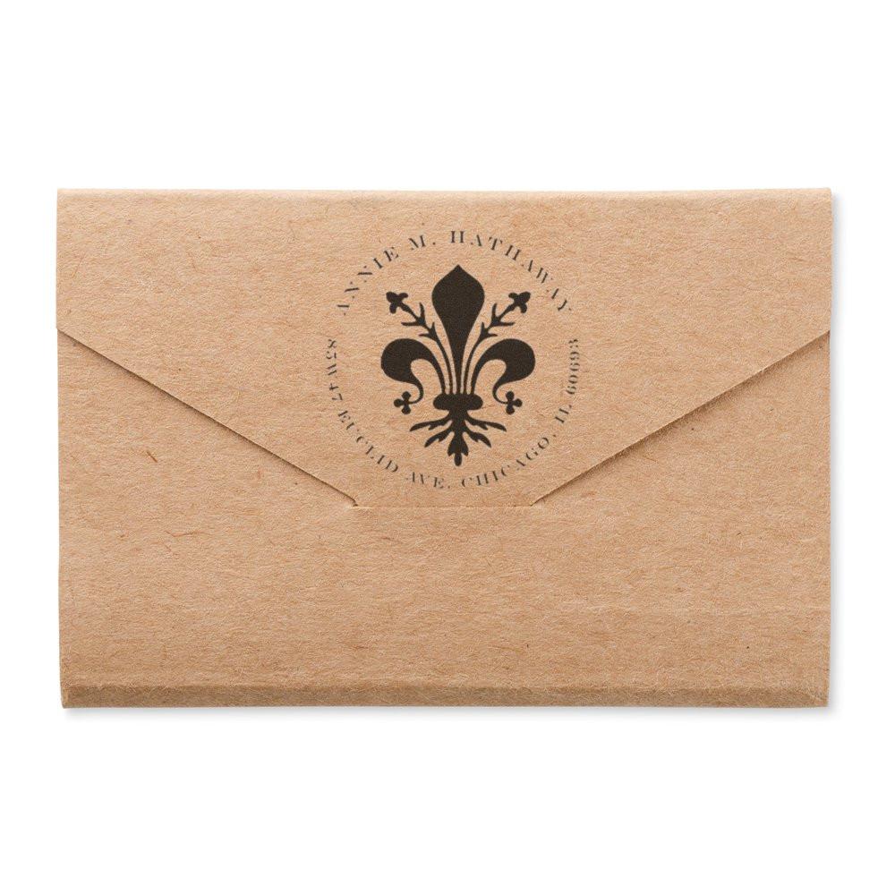 Custom rubber stamp on kraft envelope with fleur-de-lis monogram, ideal for personalized wedding invitation or business branding.